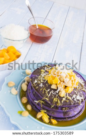 Taro pancakes topped with mango, macadamia nuts, shredded coconut and lilikoi syrup