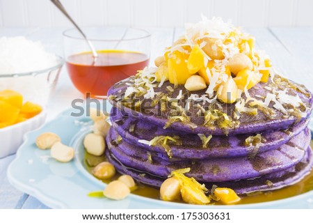 Taro pancakes topped with mango, macadamia nuts, shredded coconut and lilikoi syrup