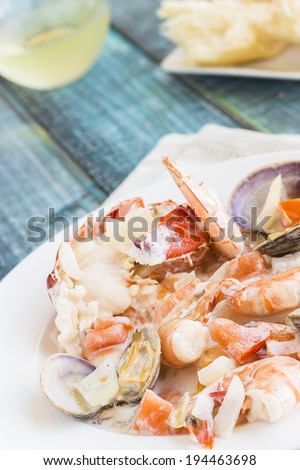 Seafood stew made with lobster, crab, shrimp and clams cooked in coconut milk with tomatoes and onions