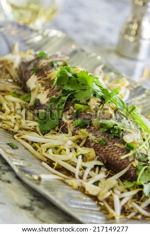 Hawaiian pink snapper boiled and served with warm soy sauce and sesame oil and topped with ginger, garlic, green onions, bean sprouts and cilantro