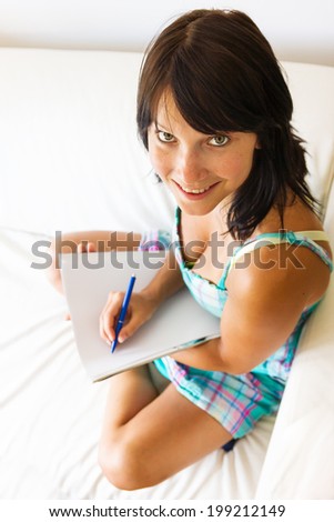 happy young woman holding a writing pad