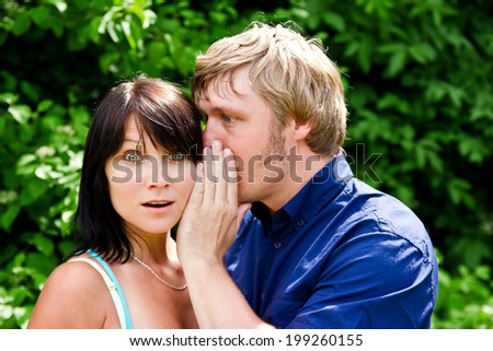 Man whispering into the woman\'s ear