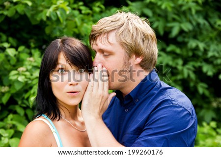 Man whispering into the woman\'s ear