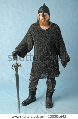 portrait of a brave knight in chain mail with a sword and a helmet with a light background