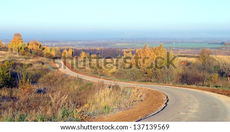 autumn landscape, the road receding into the distance beyond the horizon in the Russian fields