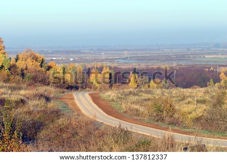 autumn landscape, the road receding into the distance beyond the horizon in the Russian fields