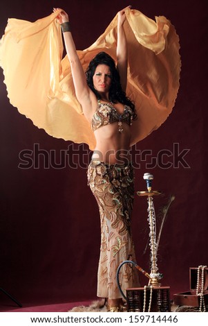 portrait of oriental girl in dance on burgundy background vertical