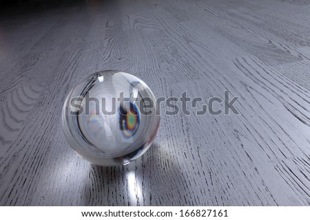 close-up clear glass ball on a gray wooden dance floor studio