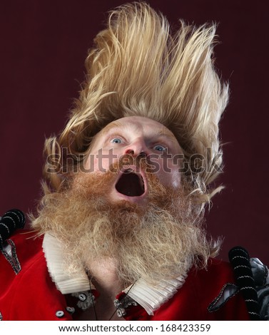 portrait of adult male with long hair beard and mustache in medieval costume tossing hair