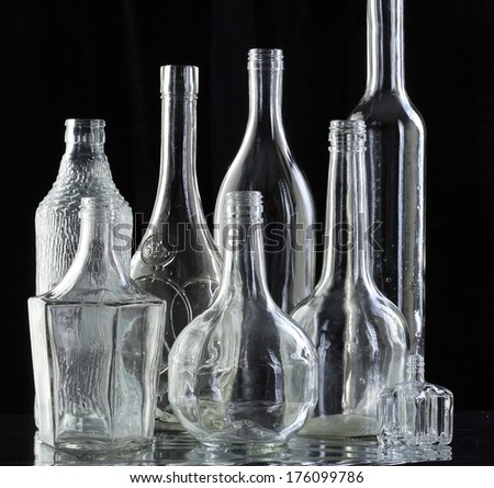 close-up beautiful transparent white empty bottles on the mirror surface on black background studio