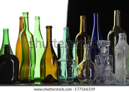 close-up collection of beautiful colored bottles of different shapes studio on black and white background