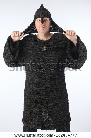 portrait of adult bald white man in chain mail and a helmet on a light background studio