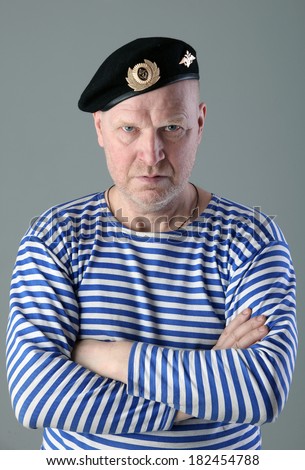 close-up portrait of adult white men in striped vest and a black beret with a serious look studio
