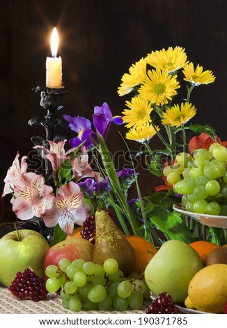 close-up elegant still life of various ripe fruits and delicate flowers on a dark background studio