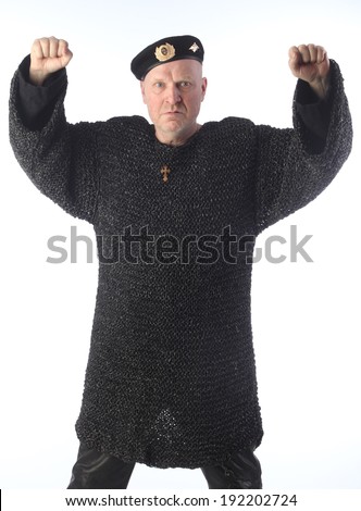 portrait of adult bald white man in black beret and chain armor on a light background studio