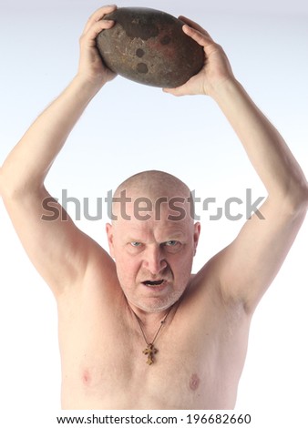 portrait of adult bald man with a naked torso throws a big round stone and shouts on white background studio