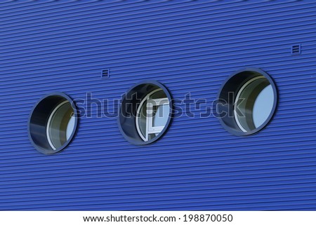 close-up modern round windows on the building of a bright blue and lamp post white round lamps