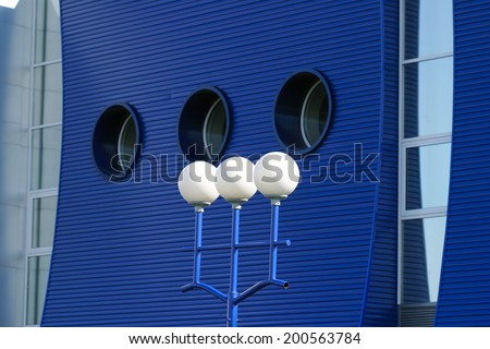 close-up modern round windows on the building of a bright blue and lamp post white round lamps