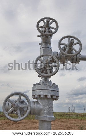 close-up big oil pipeline valves silver color on a background cloudy sky