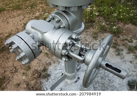 close-up big oil pipeline valves silver color on a background cloudy sky