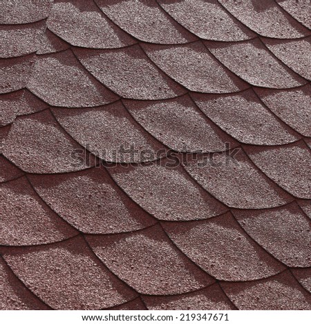 close-up texture fragment of the roof tiles with a soft red in the sunlight