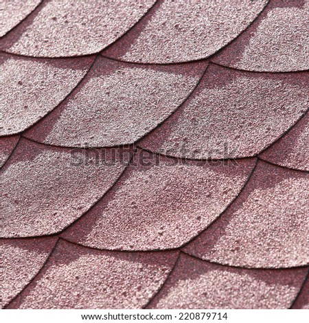 close-up texture fragment of the roof tiles with a soft red in the sunlight