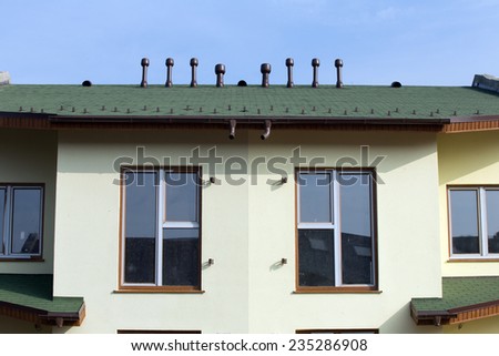 isolated fragment of the new house with a roof covered with soft green tiles
