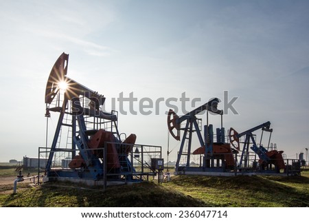 close-up the oil pumps in the meadows on a background of blue sky in the summer
