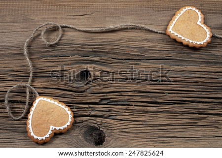close-up of cookies in the shape of heart coupled with string on the background old boards studio