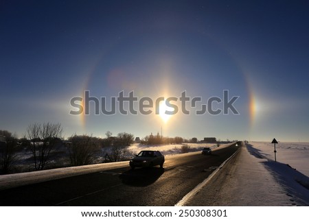 winter landscape beautiful solar halo over the desert road going over the horizon