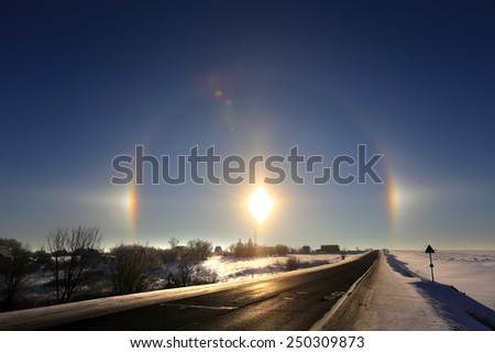 winter landscape beautiful solar halo over the desert road going over the horizon