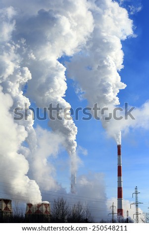 isolated close-up of white smoke from the chimney of the plant against the blue sky