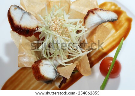 close-up gourmet salad with fish and vegetables in a basket made of dough on black background studio
