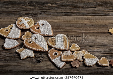 macro gingerbread heart-shaped with a yellow ribbon, flowers on wood background studio