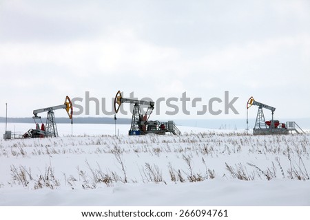 Winter industrial landscape oil pumps in a snowy field