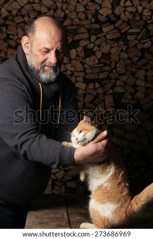 close-up ginger cat standing on its hind legs reaching for the meat in the man\'s hand