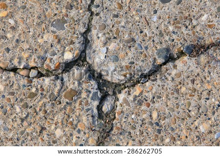 macro texture fragment of the concrete slab with cracks in the sunlight in the winter