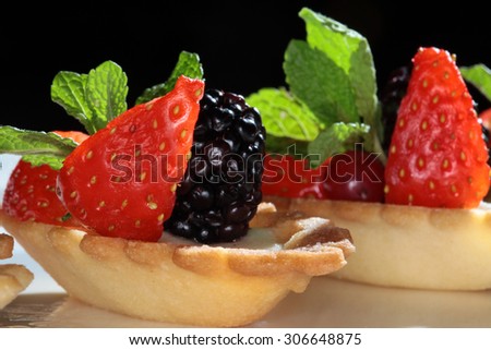 close-up delicious cake with strawberries and blackberries on a dark background Studio