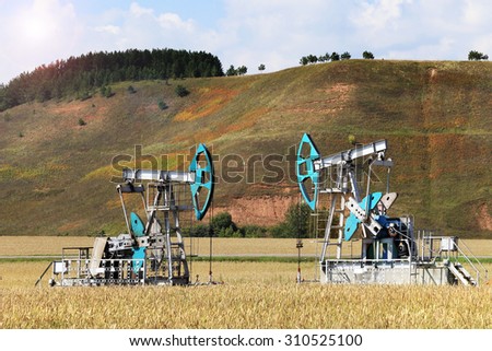 summer landscape oil pumps in a field on a clear sunny day