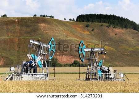 summer landscape oil pumps in a field on a clear sunny day