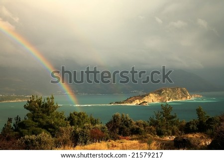 Magic moment after storm  view from hills near Budva  Montenegro. Rainbow above small bay.