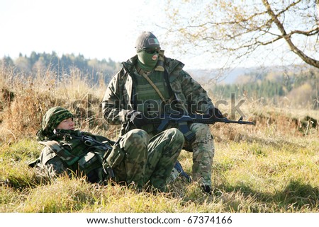 Armed soldier in camouflage is resting after the patrol.