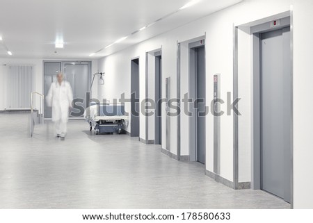 Hallway with lift and running doctor in hospital