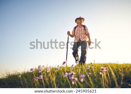 Man on summer meadow with flowers and sky