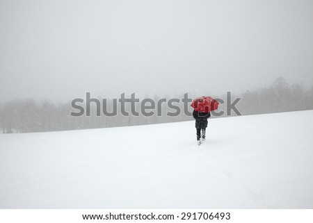Man walking in winter snow storm in the snow