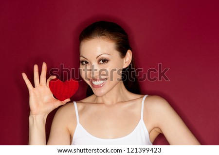 Beautiful young female with a happy smile holding a heart