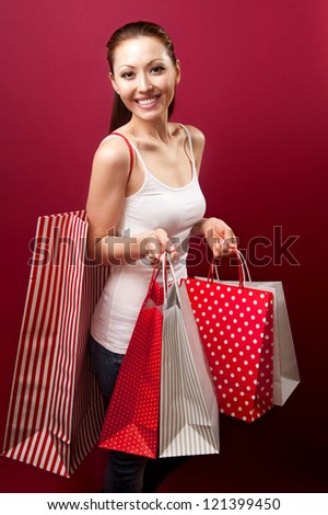 Attractive young woman holding a big bag on her shoulder happily smiling