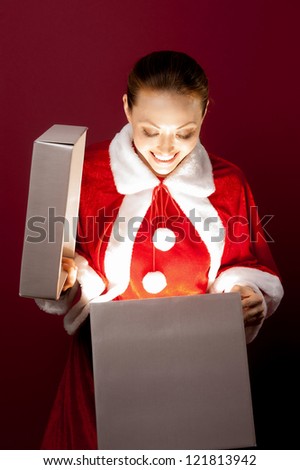 Attractive Asian Mixed Female in Christmas Outfit opening a box with a glow