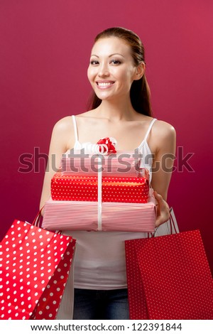 Attractive Mixed Asian Female with a big smile holding gifts and shopping bags