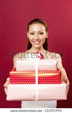 Attractive Mixed Asian Female presenting a big gift boxes